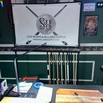 The S&H Cue Works sign next to the cue rack in the shop
