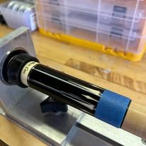 A cue butt clamped into the lathe for repair